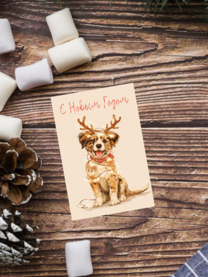 ОТКРЫТКА С ИЛЛЮСТРАЦИЕЙ СОБАКИ НА БЕЖЕВОМ ФОНЕ, С РОЖКАМИ ОЛЕНЯ НА ГОЛОВЕ И ТЕКСТОМ “С НОВЫМ ГОДОМ” (6 х 9 см)