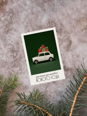 ОТКРЫТКА С ФОТО БЕЛОЙ МАШИНКИ С ПОДАРКАМИ НА КРЫШЕ НА ЗЕЛЁНОМ ФОНЕ И ТЕКСТОМ "СРОЧНАЯ ДОСТАВКА НОВОГО ГОДА" (6 х 9 см)